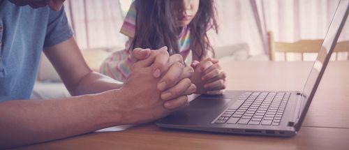 A parent and child attending an online church service