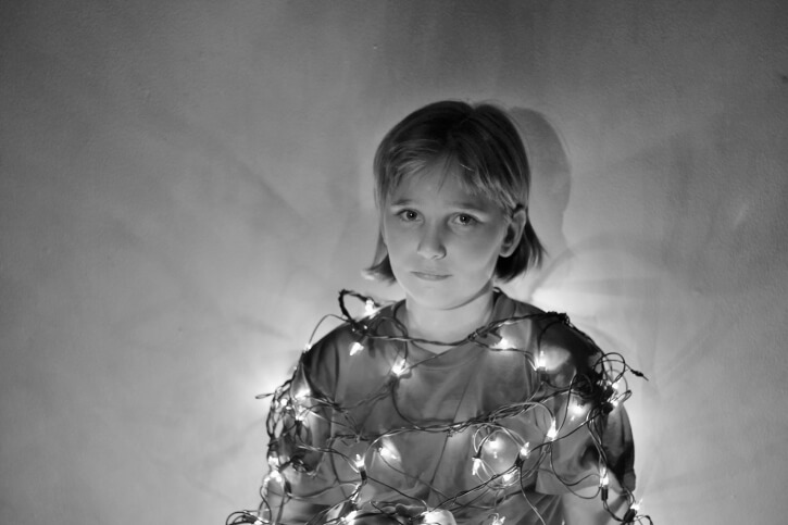 A person wrapped up in Christmas lights