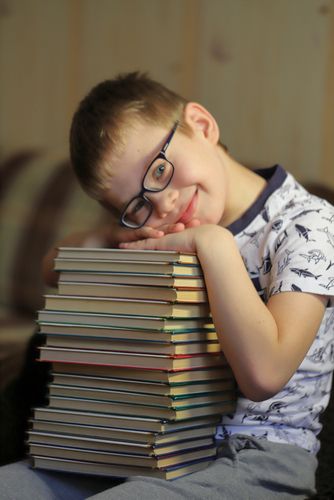 Young Boy With a Stack of Books