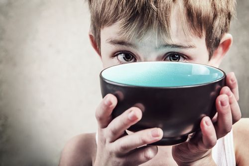 Young Child Holding an Empty Bowl