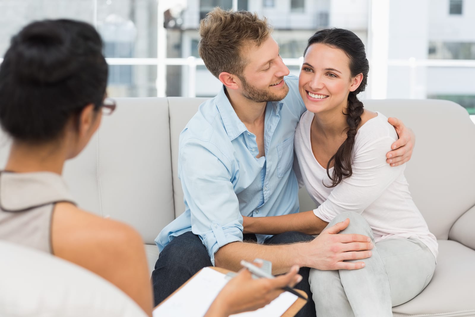 Couple on the couch talking with wedding officiant