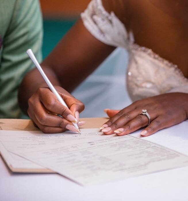 A newly-wedded woman signing her marriage license