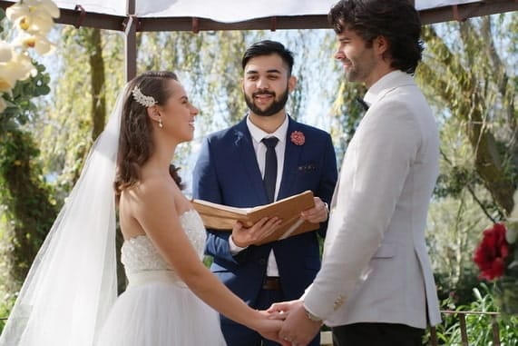 Smiling man officiating at an outdoor wedding