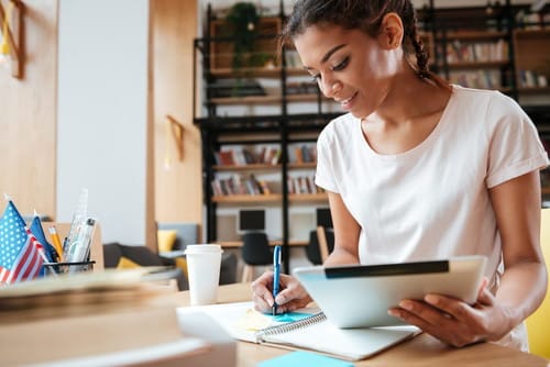 Woman writing in her notebook as she does research