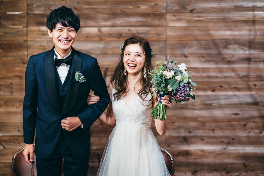 Smiling bride hudding groom after getting married at Buddhist wedding ceremony