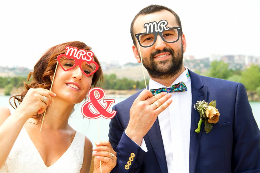 A newlywed couple wearing Mr. and Mrs. glasses.