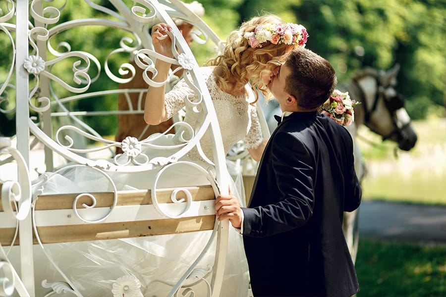 Bride in carriage kissing groom after fairytale vow renewal