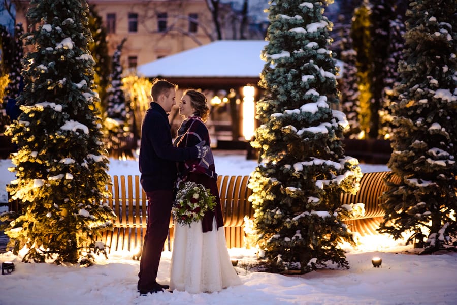 Newlywed couple kissing in the snow after winter solstice wedding